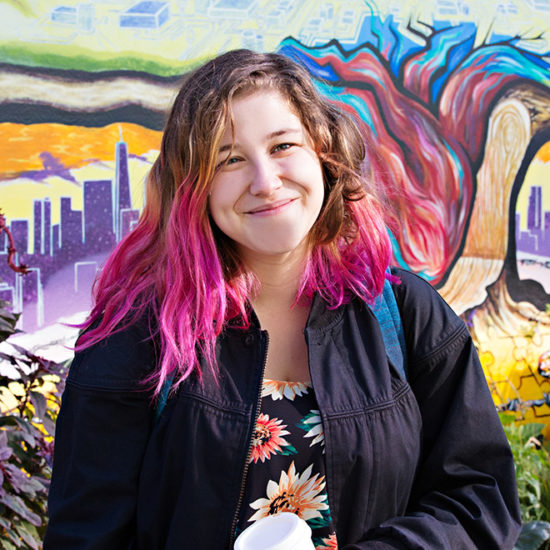 U I C student smiling in front of artwork